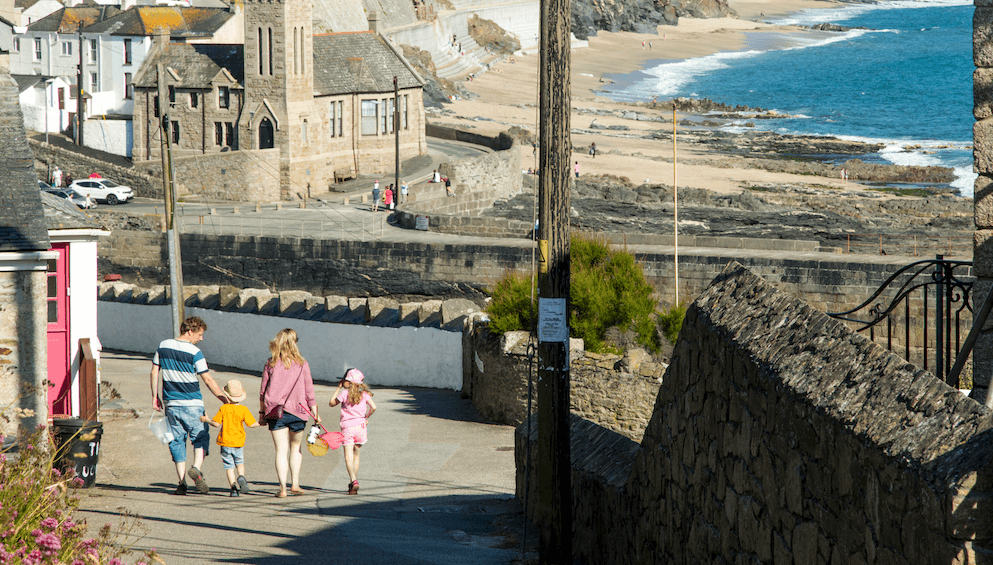 Family walking through a Cornish harbour town